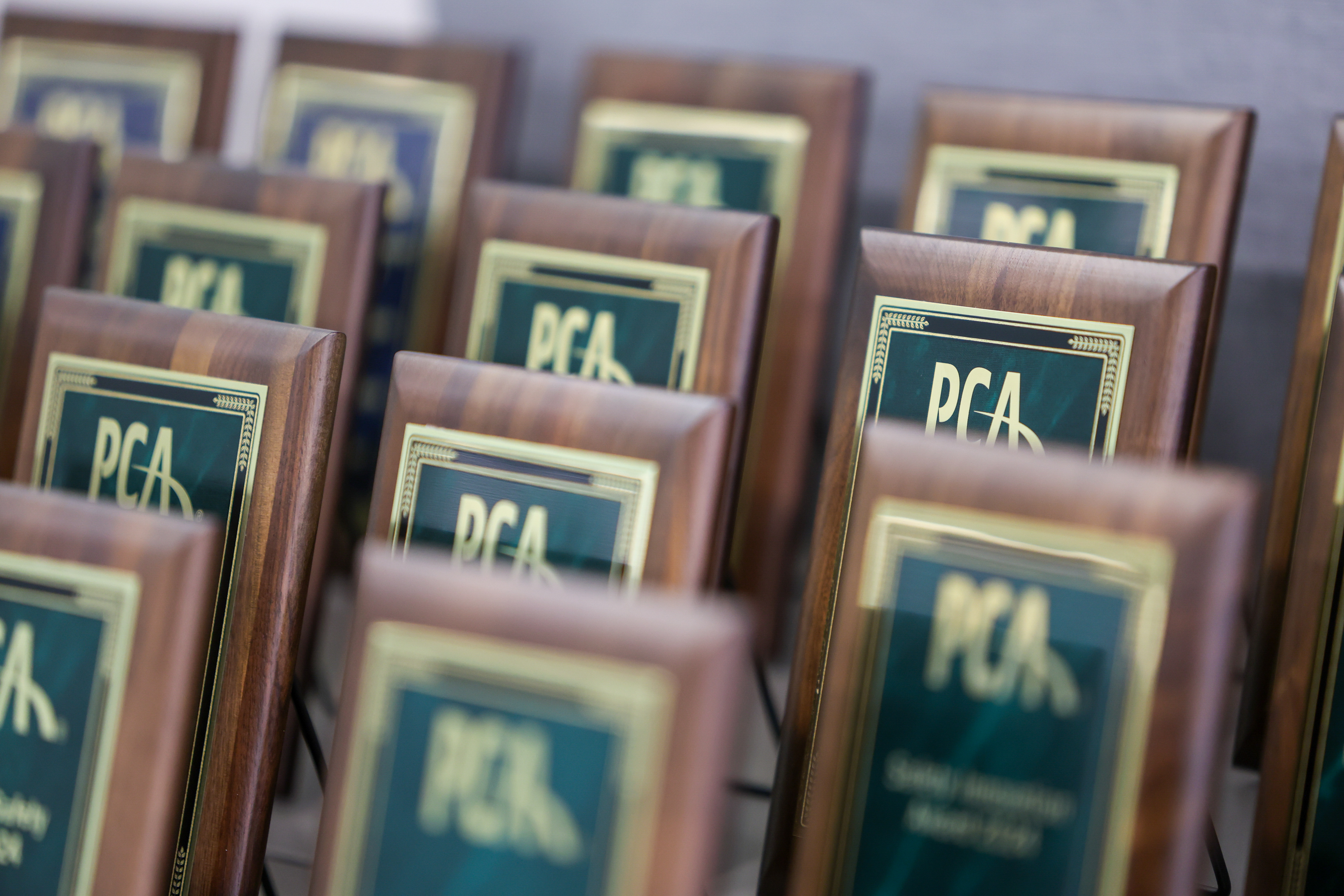 Rows of PCA awards plaques on a table